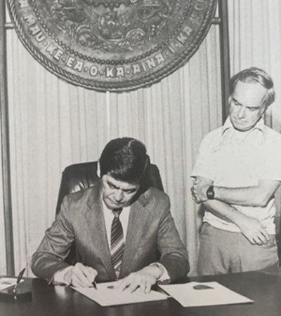 Governor George Ariyoshi signs legislation for the Tumor Registry. Former CRCH director, Dr. Lawrence H. Piette, attends.